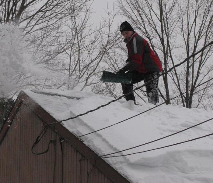 Man Shoveling Snow on Roof