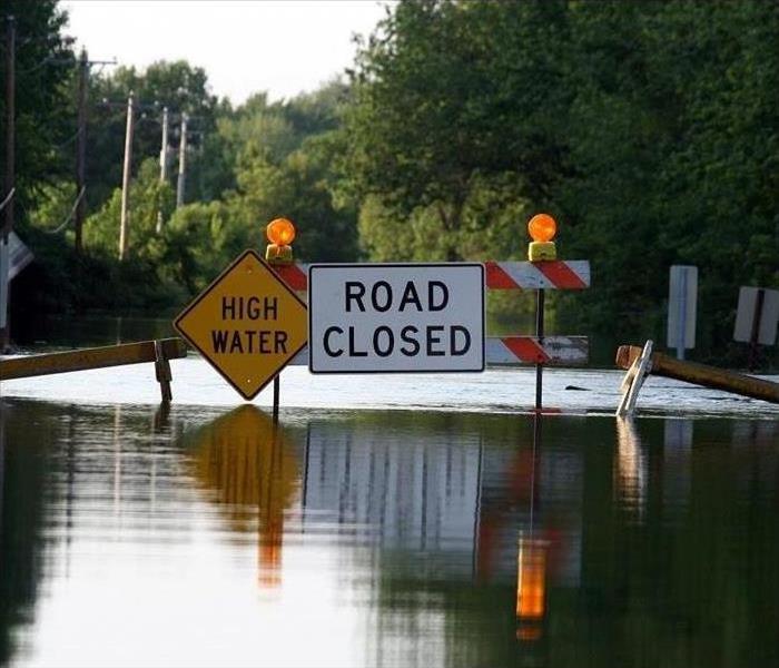 Floodwater surrounds a Road Closed sign