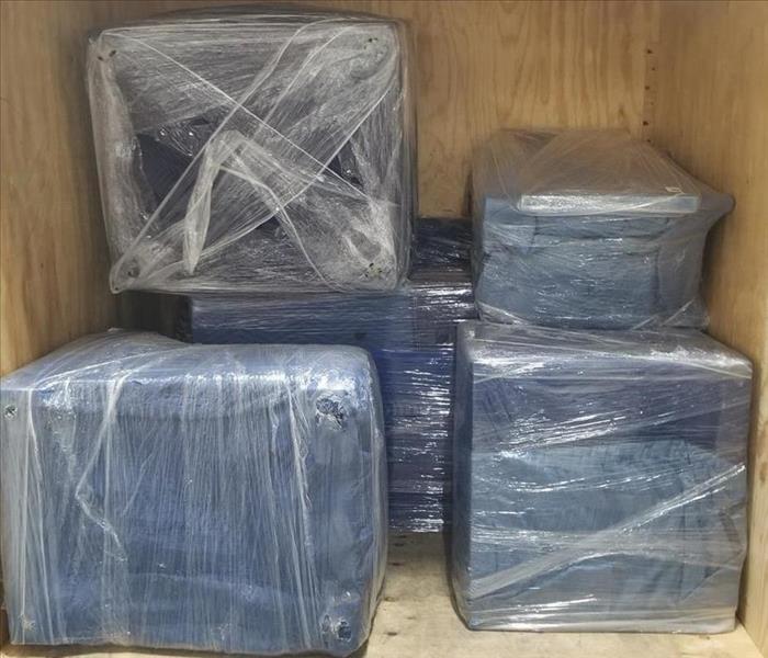 Shrink-wrapped furniture and items in a storage container